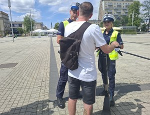 Mężczyzna na hulajnodze rozmawia z policjantami na drodze
