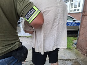 Nieumundurowany policjant doprowadza zatrzymanego