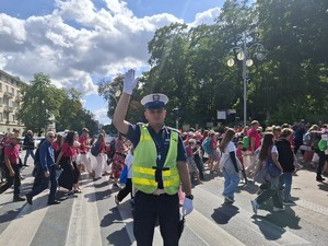 Policjant na skrzyżowaniu unosi rękę do góry