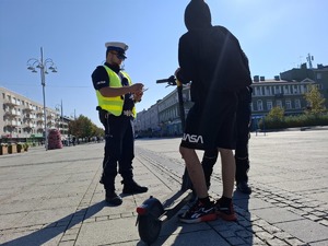 Policjant rozmawia z użytkownikiem hulajnogi