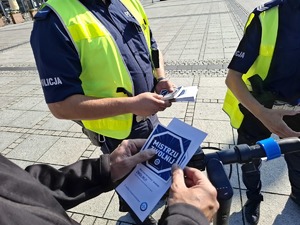 Ulotka z napisem Mistrzu zwolni w rękach przy kierownicy hulajnogi