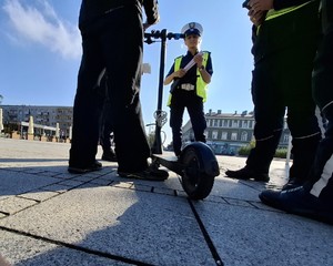 POLICJANCI ROZMAWIAJĄ Z UŻYTKOWNIKIEM HULAJNOGI