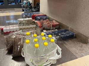 Zabezpieczone wyroby tytoniowe i butelki z alkoholem ułożone na podłodze