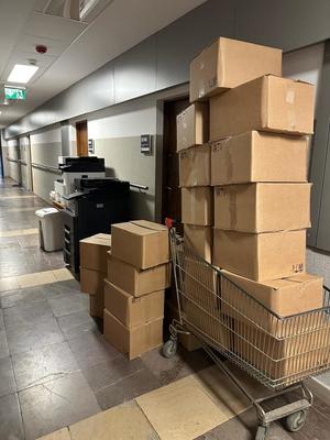 Kartony ułożone pod ścianą i w wózku