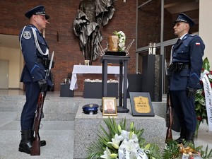 Policjanci stoją przy urnie przed ołtarzem w kościele