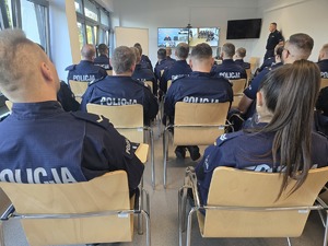 Kursanci na sali wykładowej siedzą przed ekranem