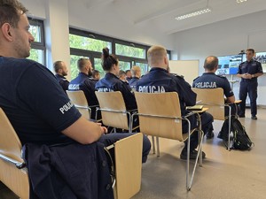 Policjanci podczas rozmowy z komendantem, który wita uczestników