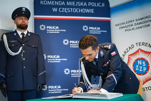 Policjant dokonuje wpisu do książki