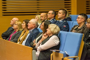 Policjanci siedzą wśród uczestników na widowni