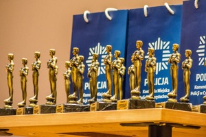 Statuetki na tle napisów Policja