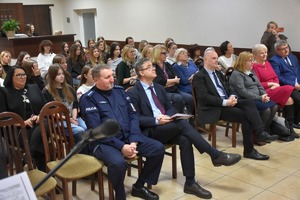 Zebrani słuchacze siedzą w sali podczas konferencji