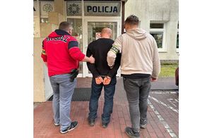 Policjanci doprowadzają zatrzymanego
