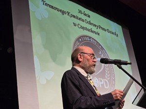 Mężczyzna podczas gali przemawia do mikrofonu