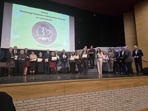 Odznaczeni uczestnicy pozują do zdjęcia ze sceny