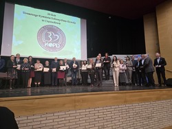 Odznaczeni uczestnicy pozują do zdjęcia ze sceny