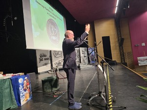 Mężczyzna ze sceny unosi rece