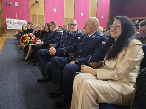 Policjanci siedzą w rzędzie wśród zaproszonych gości