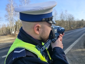 Policjant na drodze mierzy prędkość pojazdu