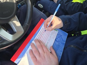 Policjant wypisuje mandat
