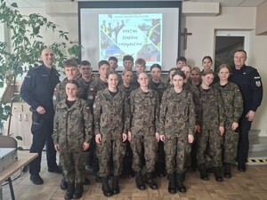 Uczniowie w mundurach pozują do zdjęcia z policjantami