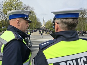 Policjanci rozmawiają na drodze, w tle wieża jasnej góry