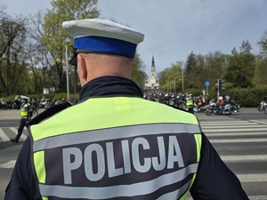 Policjant stoi przy wjeździe na jasną górę w okolicy przejścia dla pieszych