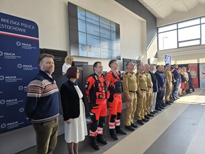 Wszyscy organizatorzy stoją w rzędzie w auli komendy