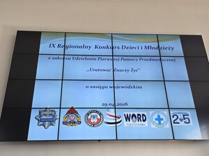 Wyświetlacz na którym jest napisane: IX Regionalny Konkurs Dzieci i Młodzieży z zakresu udzielania pierwszej pomocy przedmedycznej "Uratować znaczy żyć " o zasięgu wojewódzkim- 29.04.2029