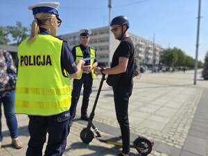 Policjanci rozmawiają z użytkownikiem hulajnogi