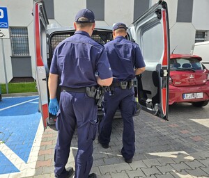 Policjanci otwierają drzwi radiowozu