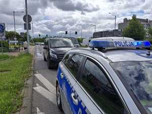 Karawan i radiowóz policyjny stoją przy drodze