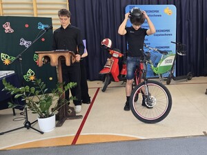 Chłopak na rowerze podczas akademii ubiera kask na głowę