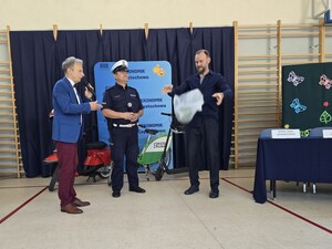 Policjant i dyrektor stoją obok mężczyzny, który trzyma arbuza w rękach