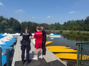 Policjanci rozmawiają z ratownikiem przy zbiorniku wodnym