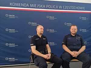 Policjanci siedzą na krzesłach na tle ścianki z napisem Policja