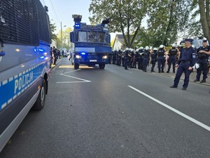 Policyjna armatka stoi na drodze wśród policjantów
