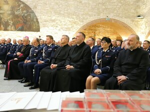 Policjanci siedzą w sali razem z klerykami