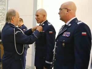 Policjant dekorowany medalem przez policjanta w mundurze