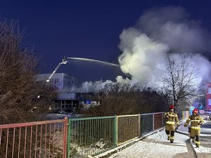 Zdjęcie przedstawia pożar budynku gaszony przez strażaków.