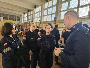 Umundurowani policjanci i kadeci liceum o profilu mundurowym na targach pracy.