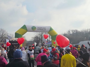 Umundurowani policjanci i radiowozy oznakowane, zabezpieczający bieg walentynkowy.