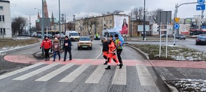 Umundurowani policjanci i radiowozy oznakowane, zabezpieczający bieg walentynkowy.