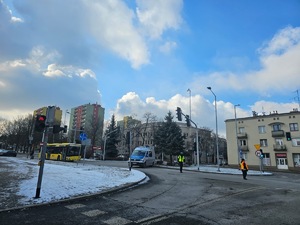 Umundurowani policjanci i radiowozy oznakowane, zabezpieczający bieg walentynkowy.