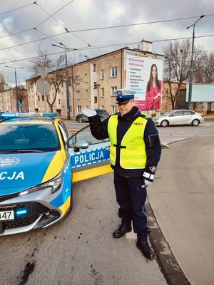 Umundurowani policjanci i radiowozy oznakowane, zabezpieczający bieg walentynkowy.