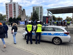 Umundurowani policjanci i oznakowane radiowozy oraz pracownicy przemysłu koksowniczego podczas zabezpieczenia manifestu.