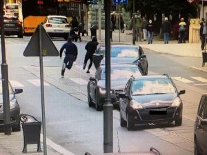 Ruchliwa ulica i widoczny pościg pieszy za podejrzanym mężczyzną