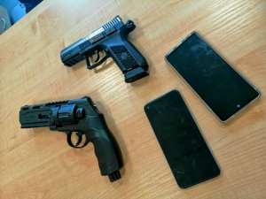 Dwa pistolety i dwa telefony typu smartfon.