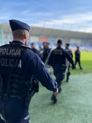 Policjanci z tarczami na stadionie piłkarskim.