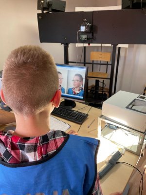 Chłopiec ogląda monitor z wykonanymi swoimi zdjęciami.