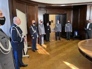 Generał Rafał Kochańczyk przemawia, obok widzimy innych oficerów policji, w tle księdza kapelana, po prawej odchodzący na emeryturę aspirant sztabowy Dariusz Wygodny.